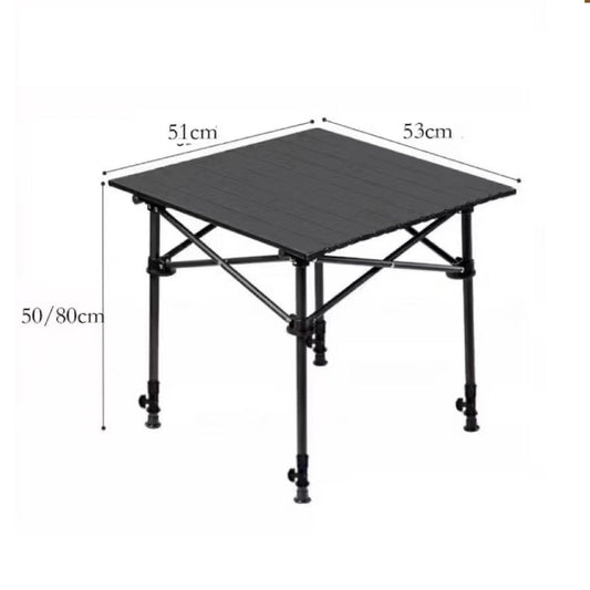 Black ECOTREK adjustable folding camping table set up outdoors next to a tent, showing its compact and portable design.