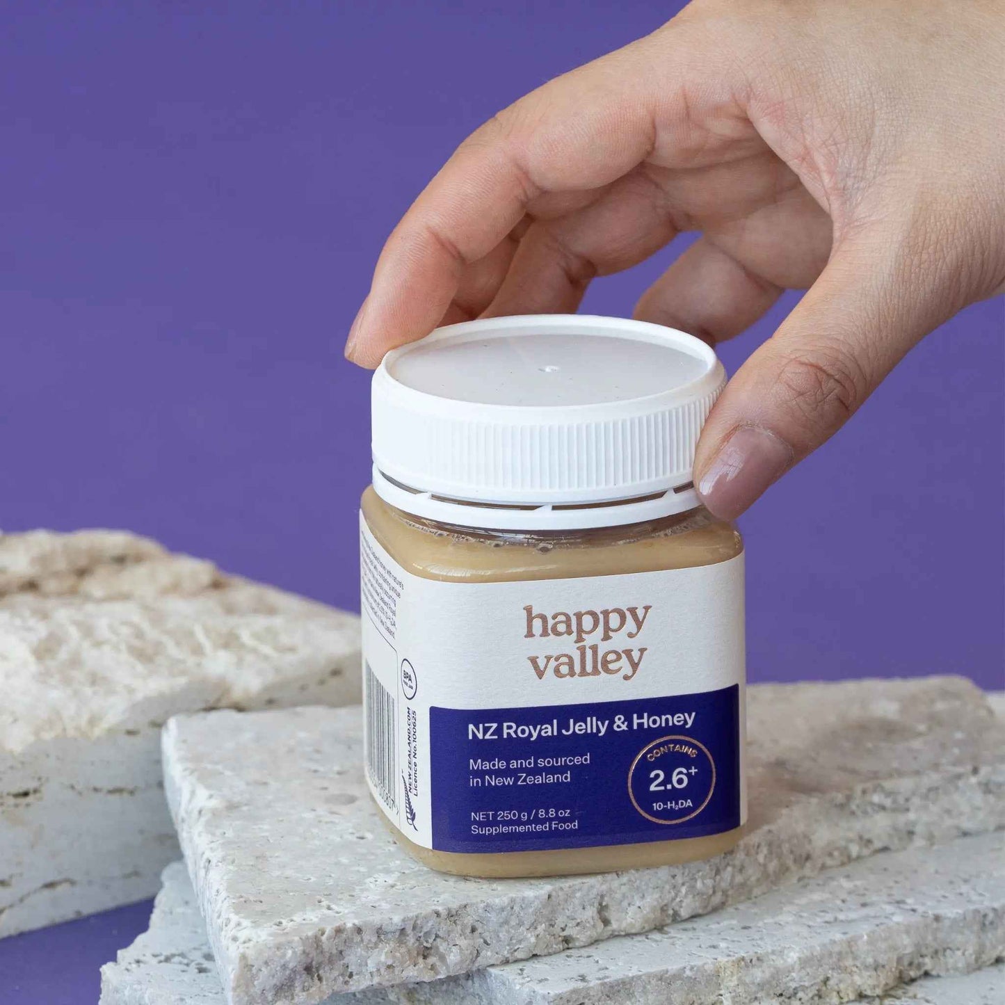 Jar of Happy Valley Honey Royal Jelly with honeycomb and honey drizzles, showcasing fresh royal jelly and honey in a glass jar.