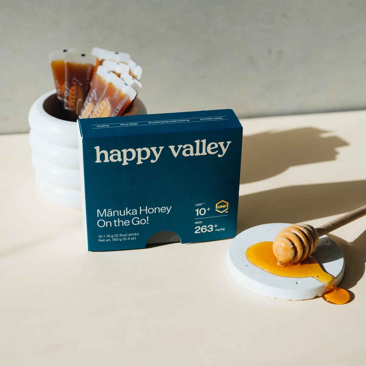 Two Happy Valley Honey Manuka Honey packets with UMF 10+ sticks for on-the-go use, featuring golden honey inside portable packaging.