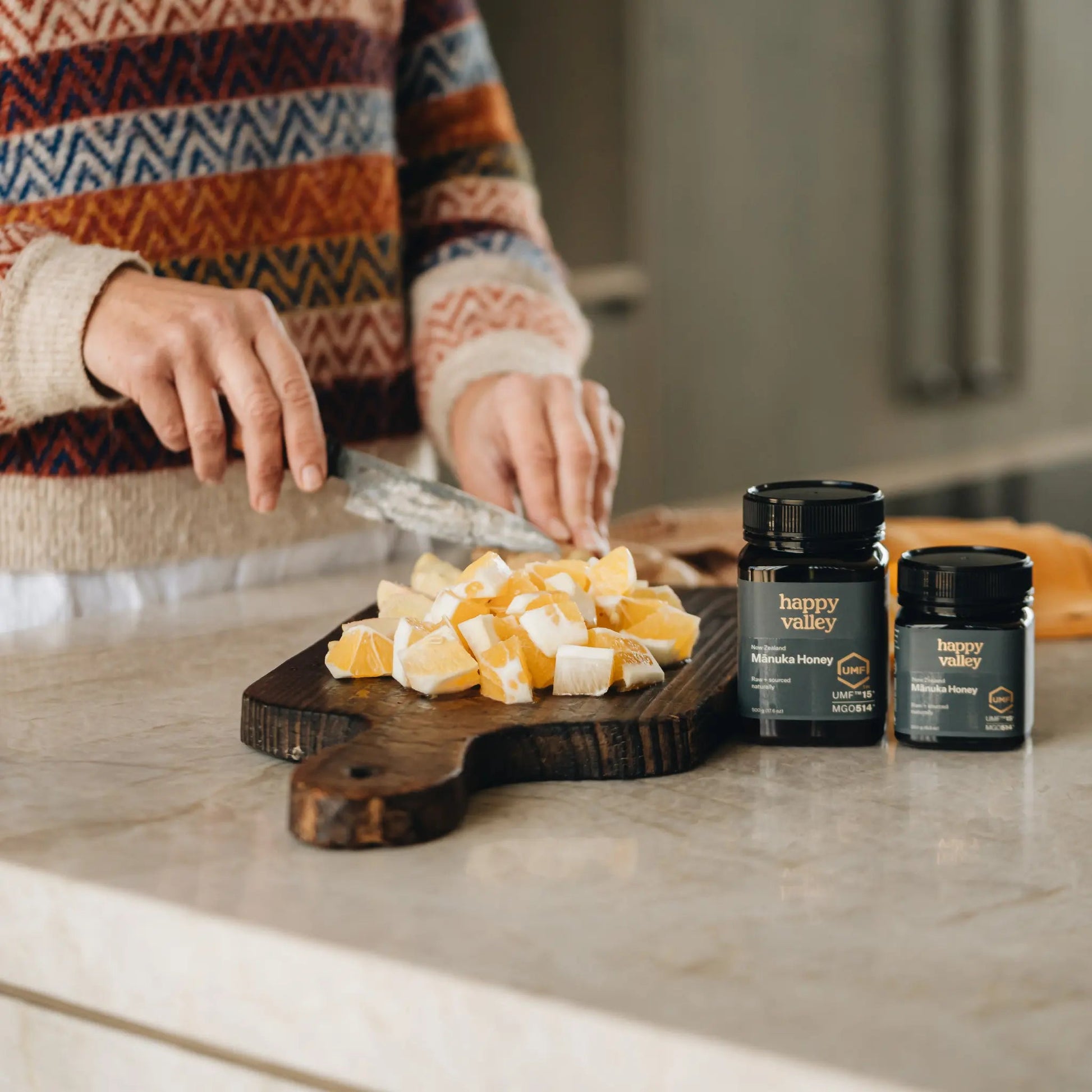 Jar of Happy Valley Honey Manuka Honey UMF® 15+ with golden honey drizzled on a spoon, highlighting natural, pure Manuka honey.