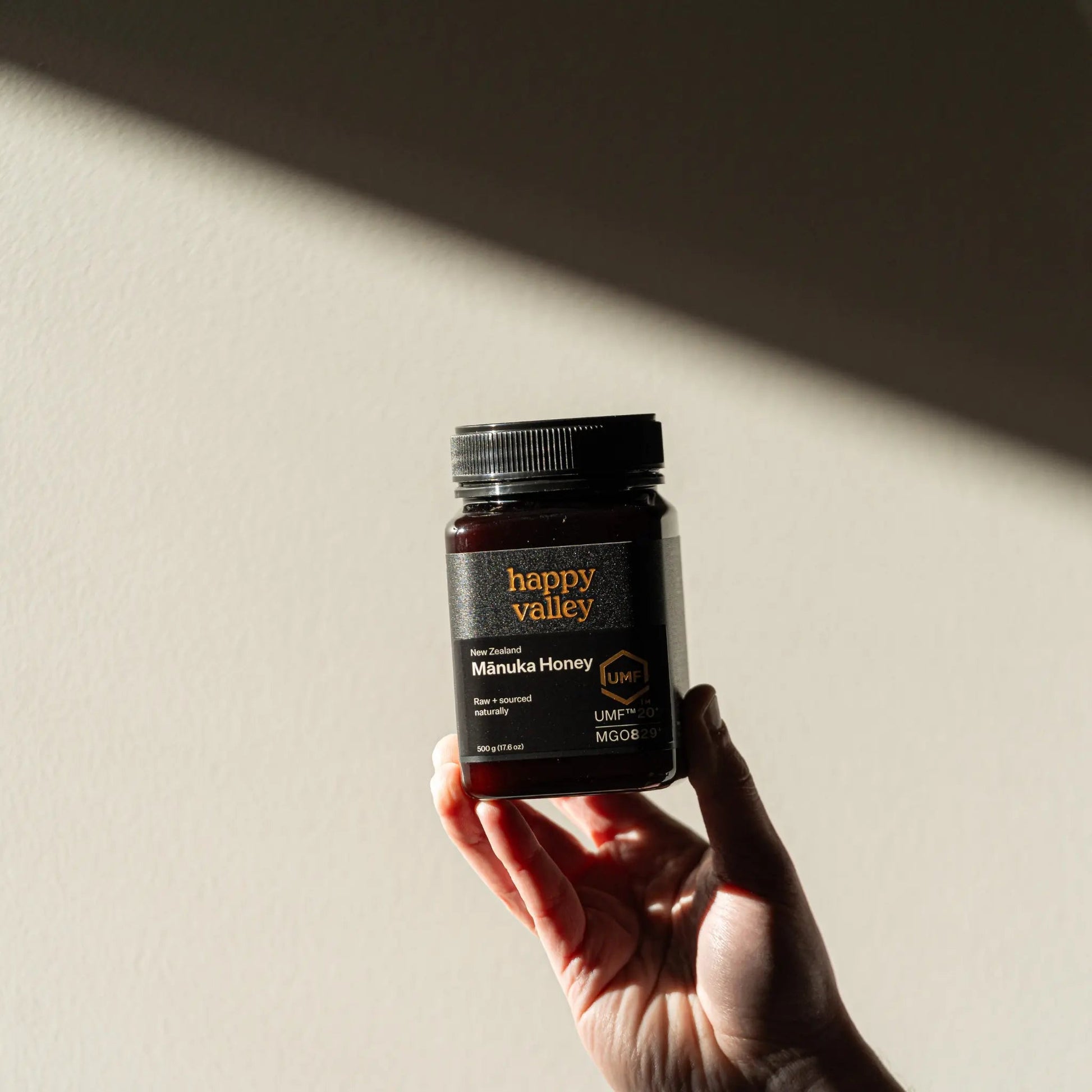 Jar of Happy Valley Honey Mānuka Honey UMF® 20+ with golden honey inside, showcasing premium manuka honey quality.