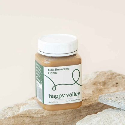 Jar of Rewarewa native honey from Happy Valley Honey, showcasing golden, thick, raw gourmet honey with a natural honeycomb texture.
