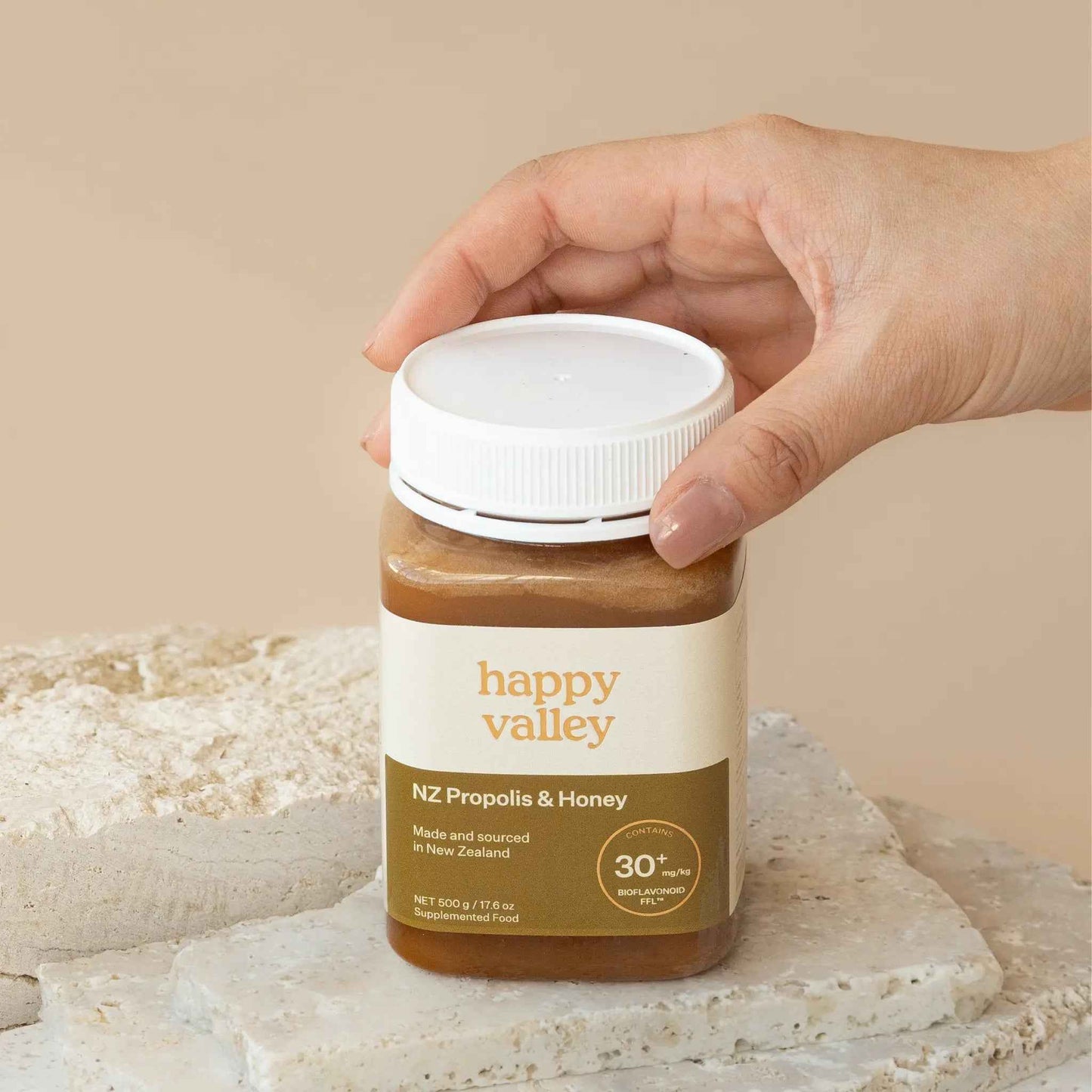 Jar of Happy Valley Honey Propolis with honeycomb and propolis chunks, showcasing natural bee product and golden color.