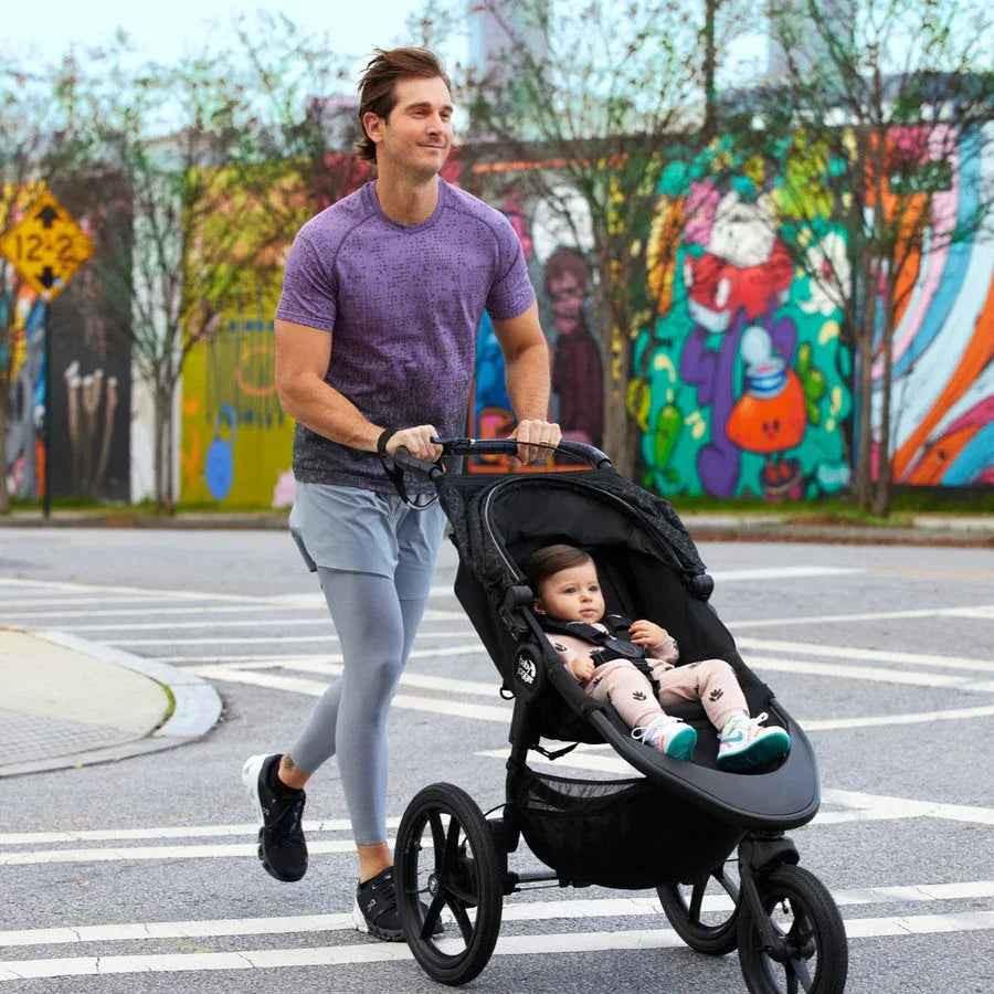 Baby Jogger Summit X3 jogging stroller in midnight black, featuring sturdy wheels and adjustable canopy for active outdoor walks.
