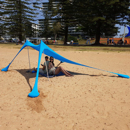 Green ECOTREK portable beach canopy with sun shade awning providing shelter and shade at the beach
