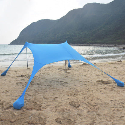 Green ECOTREK portable beach canopy sun shade awning providing shade and protection at the beach