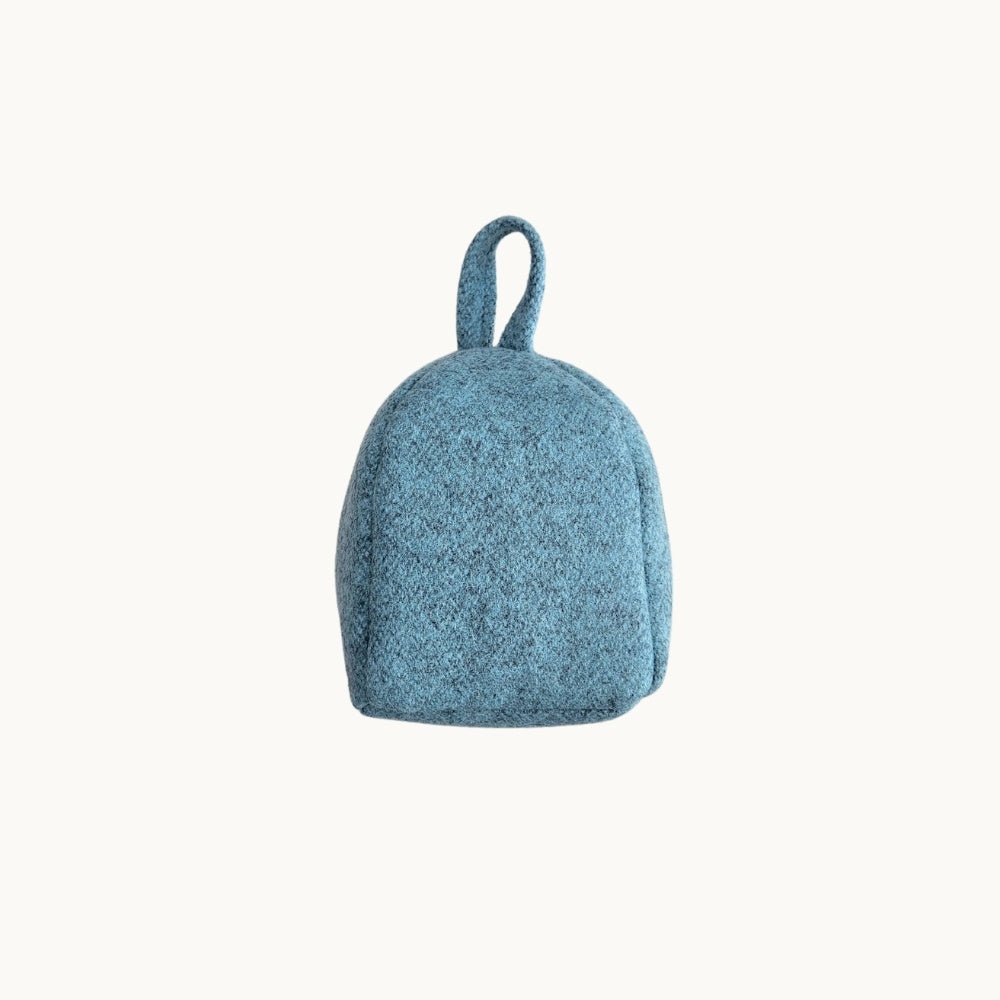 Felted New Zealand wool door stop from Do Not Disturb Sleep Company, soft gray, rounded shape for securely holding doors open.