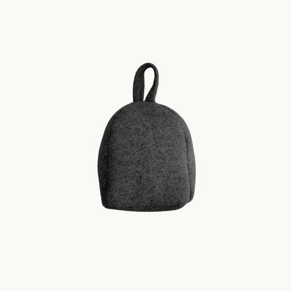Felted NZ wool door stop from Do Not Disturb Sleep Company, soft and textured with a rounded shape for door stability.