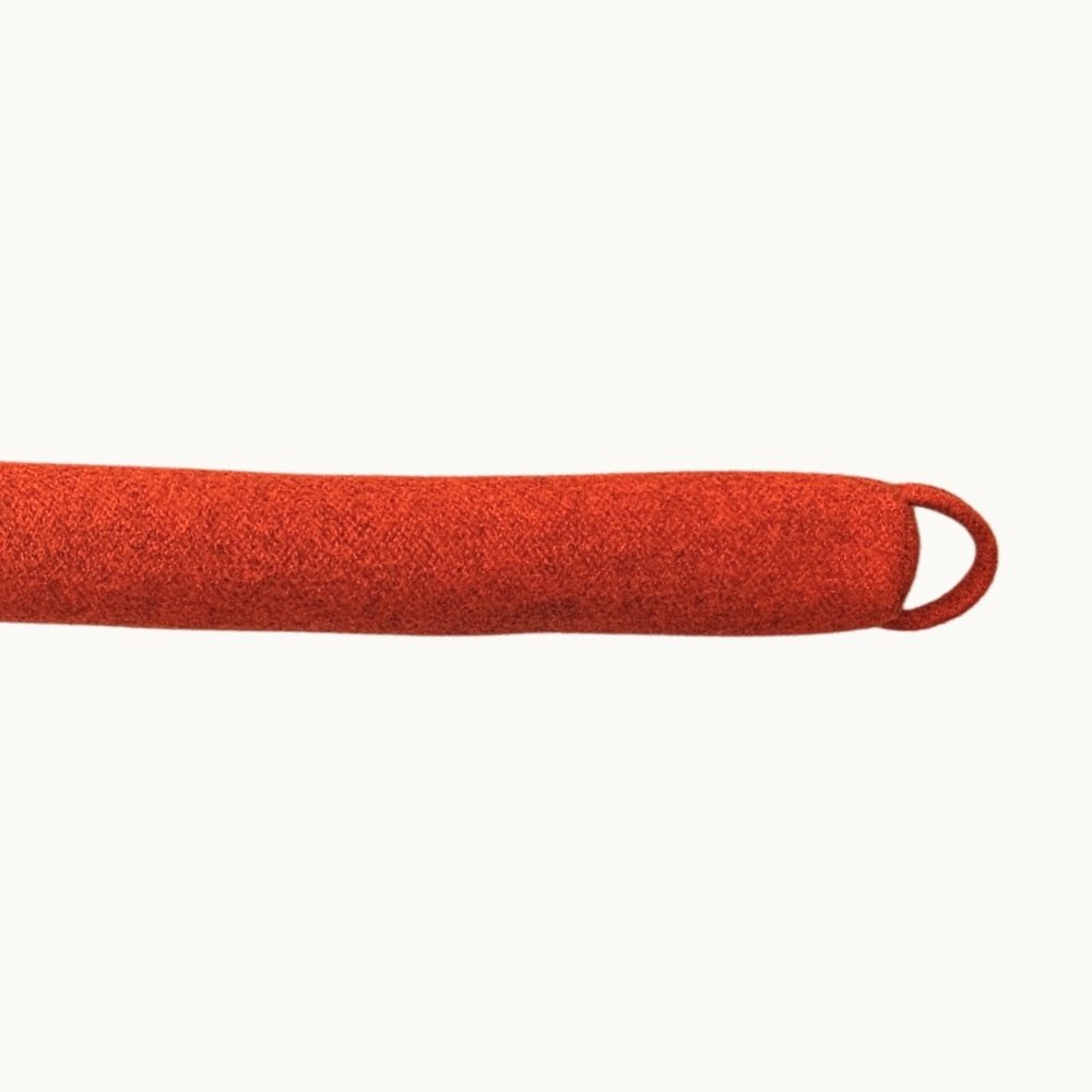 Felted NZ wool draught stopper from Do Not Disturb Sleep Company blocking a door gap to prevent drafts and heat loss.