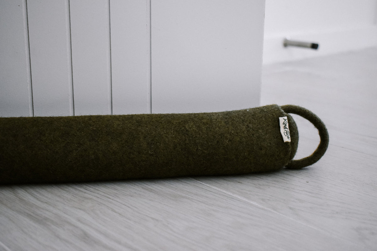 Felted New Zealand wool draught stopper from Do Not Disturb Sleep Company blocking a door gap.