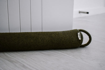 Felted New Zealand wool draught stopper from Do Not Disturb Sleep Company blocking a door gap.