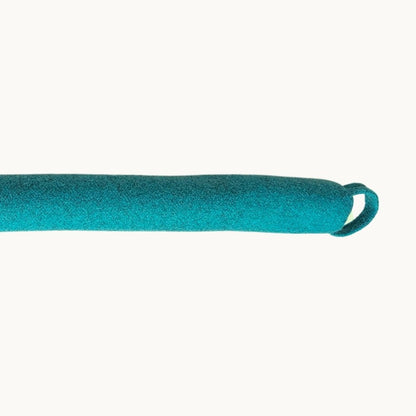 Felted New Zealand wool draught stopper by Do Not Disturb Sleep Company sitting at door base to block drafts and improve insulation.