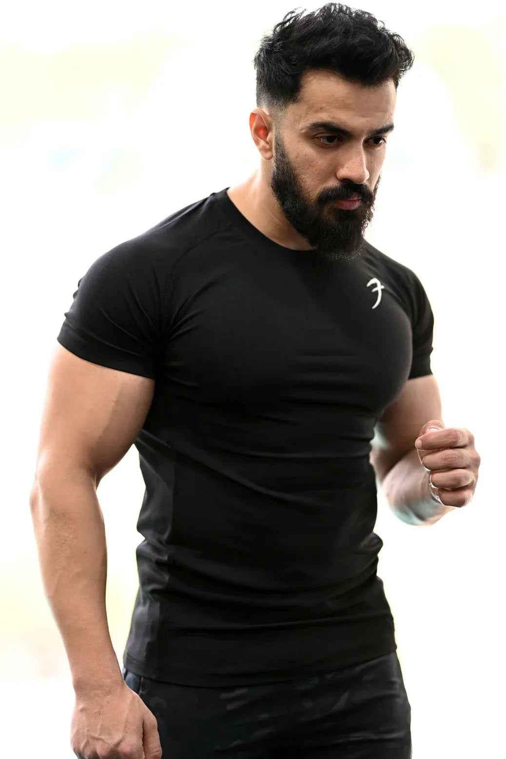 Black Fuaark Nz Performance T-shirt laid flat, showing its sleek design and soft fabric for active wear.