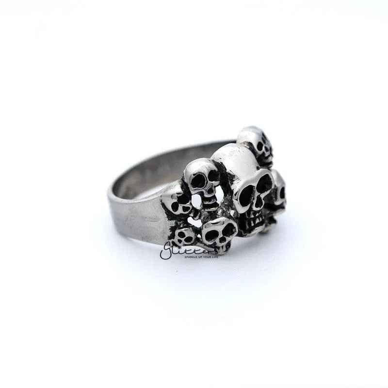 Stainless steel men's ring with antiqued finish and multiple skull head designs, from Glitters.