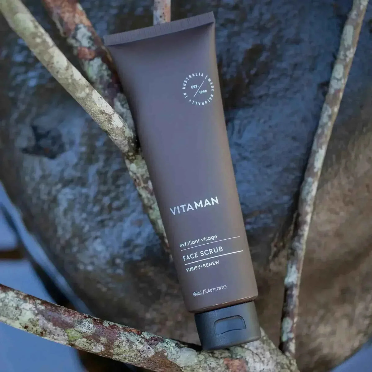 VITAMAN Australia face scrub for skincare, showing a close-up of the product container with fresh botanical ingredients.